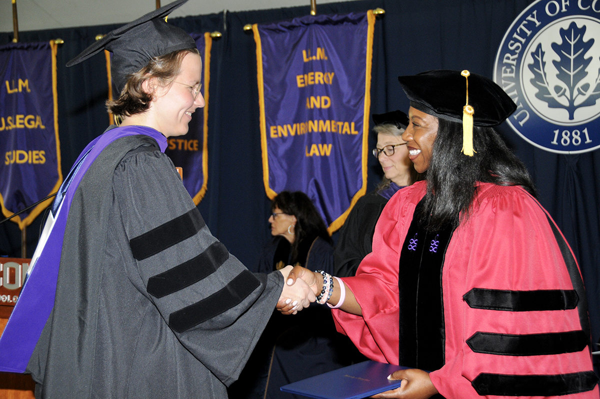 Dean Eboni S. Nelson shaking graduate's hand