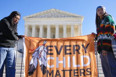 People holding sign in front of U.S. Supreme Court: Every Child Matters